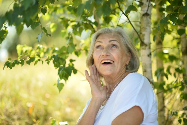 Portrait d'une femme senior souriante heureuse dans le parc