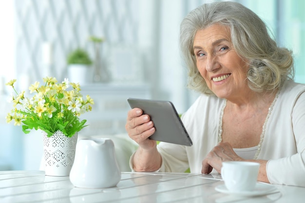 Portrait de femme senior souriante avec tablette