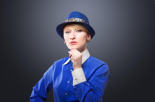 Portrait d'une femme sérieuse dans un chapeau regardant la caméra