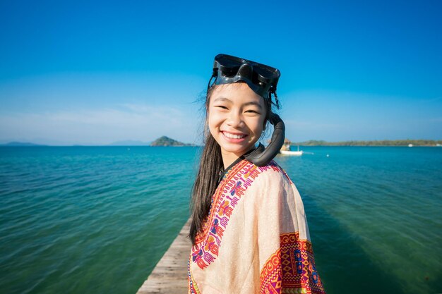 Portrait d'une femme avec un snorkel debout sur la jetée