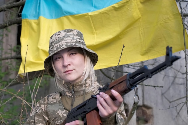 Portrait d'une femme soldat en uniforme de camouflage regardant la caméra
