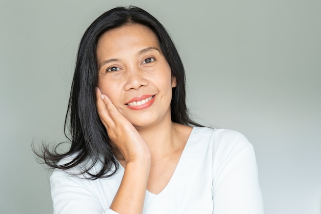 Portrait de femme souriante d'âge moyen aux cheveux noirs