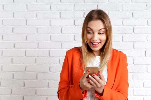 Portrait d&#39;une femme souriante à l&#39;aide de smartphone