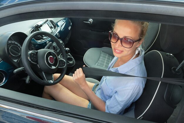 Photo portrait d'une femme souriante assise dans une voiture