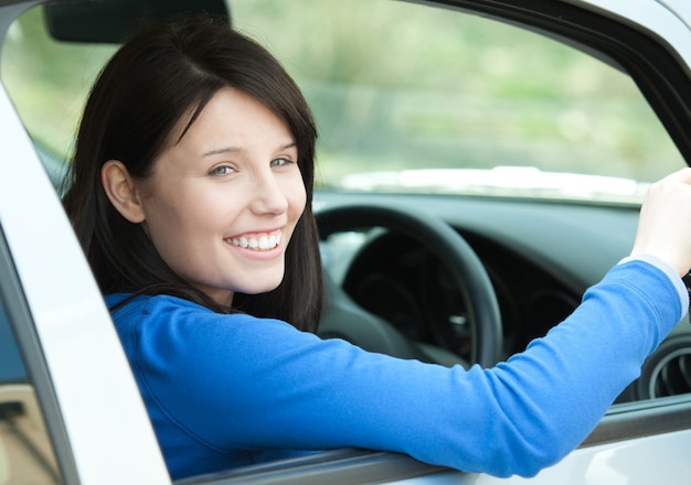 Portrait d&#39;une femme souriante au volant