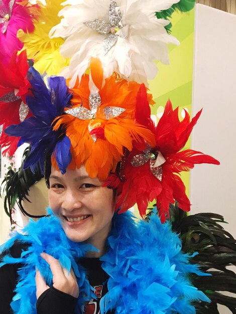 Photo portrait d'une femme souriante avec un boa à plumes