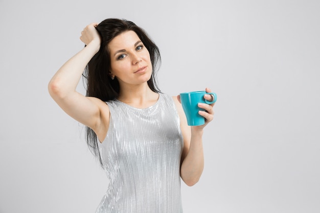 Portrait de femme souriante brunet en chemisier tenant une tasse