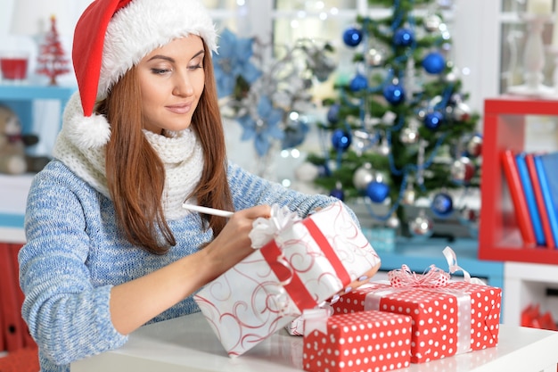 Portrait de femme souriante avec des cadeaux de Noël à la maison