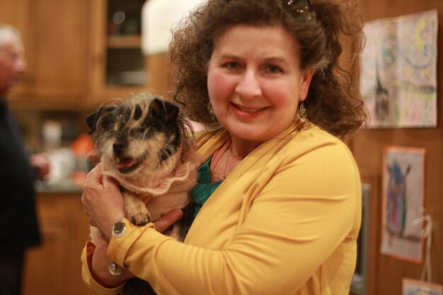 Photo portrait d'une femme souriante avec un chien à la maison