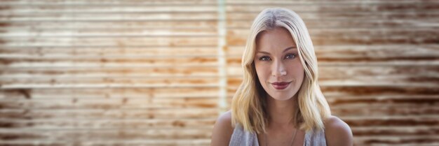 portrait de femme souriante contre un panneau de bois flou