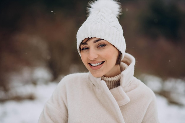 Portrait de femme souriante dans la forêt d'hiver