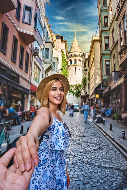 Photo portrait d'une femme souriante dans la rue contre les bâtiments de la ville