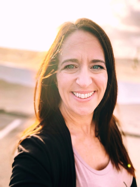 Portrait d'une femme souriante debout à l'extérieur