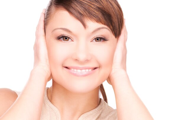 Portrait de femme souriante avec les mains sur les oreilles