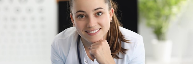 Portrait d'une femme souriante ophtalmologiste au bureau de la clinique