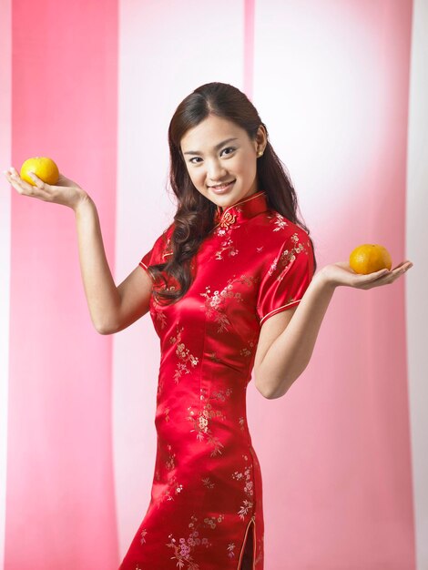 Photo portrait d'une femme souriante avec des oranges sur le fond