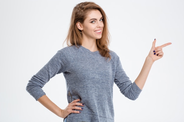 Portrait d'une femme souriante pointant vers l'extérieur isolé sur fond blanc