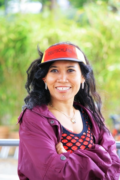 Portrait d'une femme souriante portant un chapeau contre les plantes