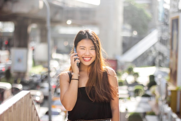 Portrait d'une femme souriante qui parle au téléphone portable