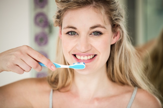 Portrait de femme souriante se brosser les dents