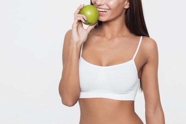 Portrait de femme souriante séduisante sur fond blanc avec pomme