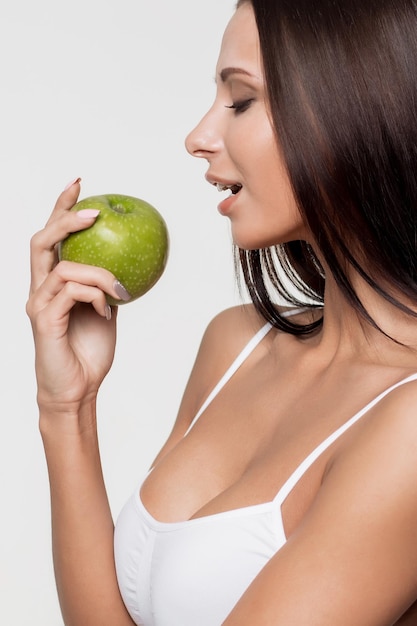 Portrait de femme souriante séduisante sur fond blanc avec pomme