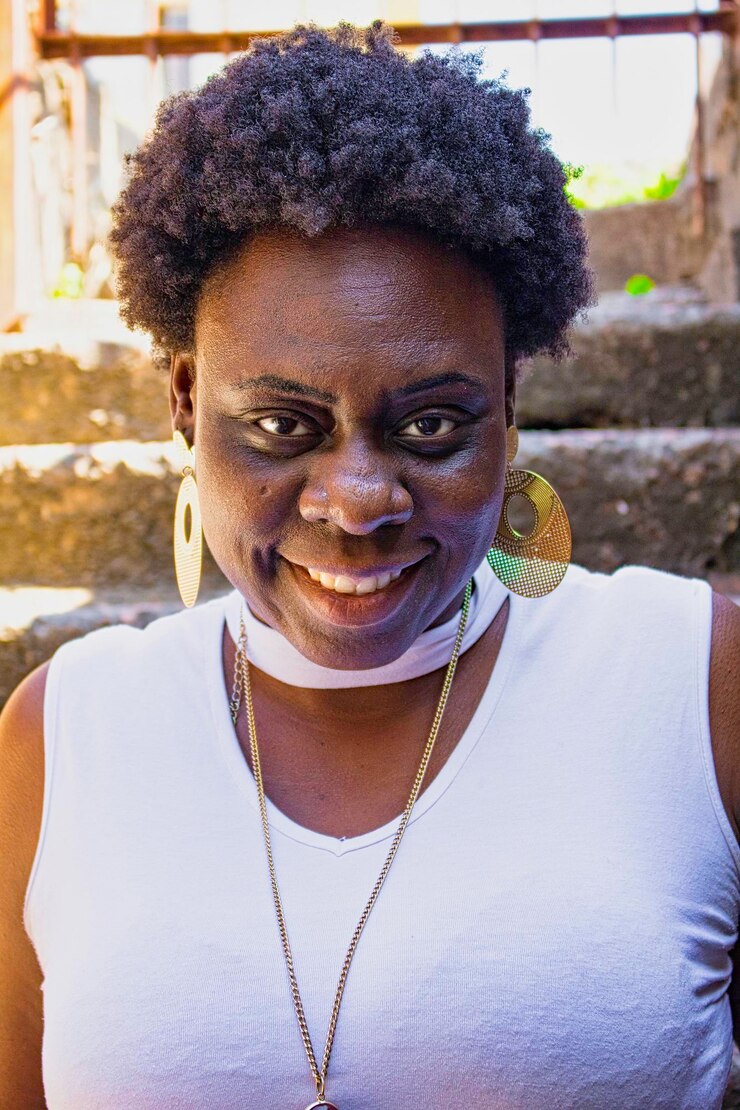 Photo portrait d'une femme souriante avec un tatouage qui détourne le regard