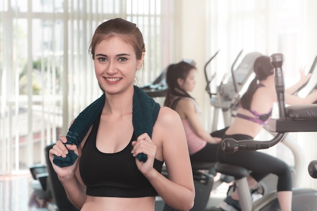 Portrait d&#39;une femme sportive debout dans une salle de fitness avec serviette