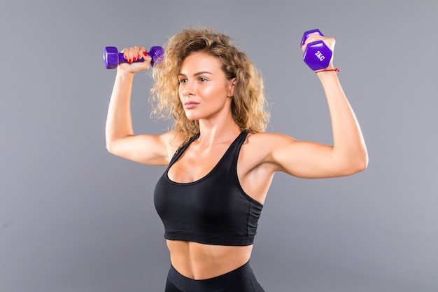 Portrait De Femme Sportive Mince, Faire Des Exercices Avec De Petits Haltères Isolés Sur Mur Gris