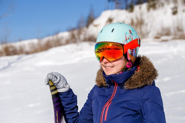 Portrait de femme sportive portant un casque avec snowboard regardant la caméra