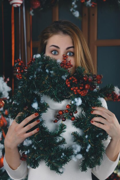 Portrait d'une femme tenant un arbre de Noël à la maison