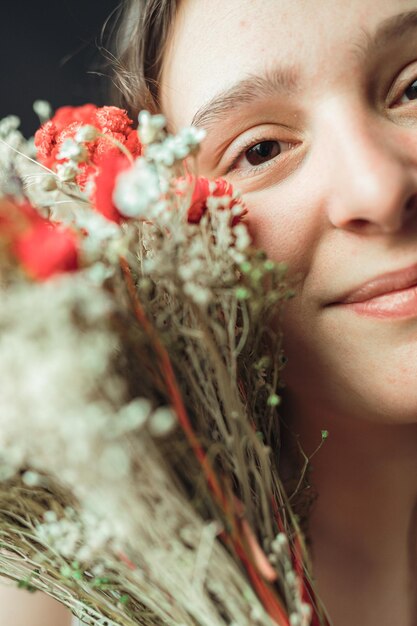 Portrait d'une femme tenant un bouquet coloré de fleurs Beauté bien-être ou soins de la peau avec une esthétique printanière en toile de fond Fille et plante d'oeillet pour la santé cosmétique éclat de la peau et heureux pour la croissance