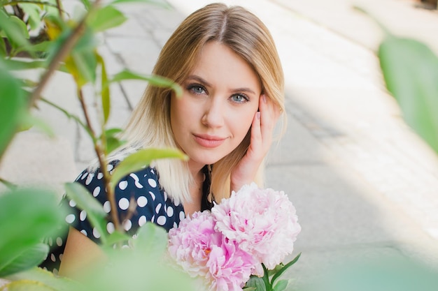 Portrait d'une femme tenant des pivoines