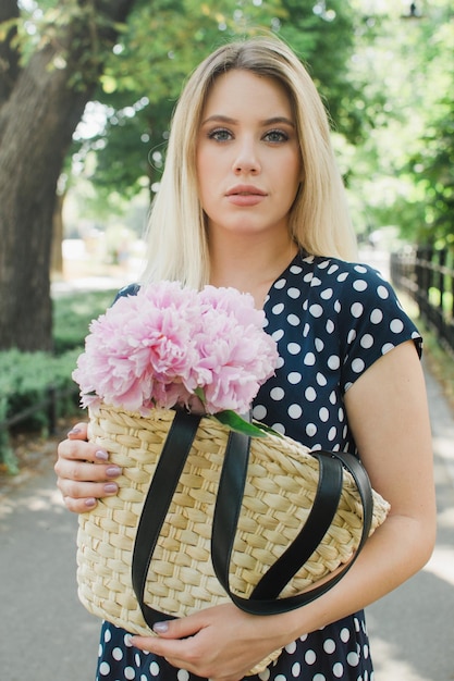 Portrait d'une femme tenant des pivoines