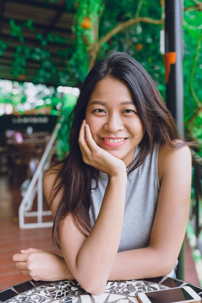 Portrait de femme thaïlandaise asiatique mignon assis dans le café se détendre posture avec sourire dentaire