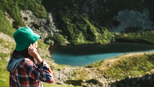 Portrait d'une femme touriste sur fond de montagnes verdoyantes et de lac