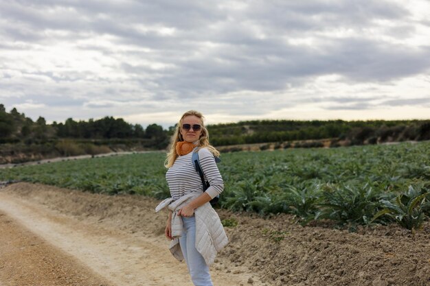 Le portrait d'une femme touristique regarde les champs agricoles d'artichaut