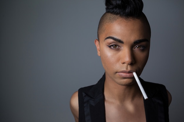 Portrait de femme transgenre avec cigarette dans la bouche