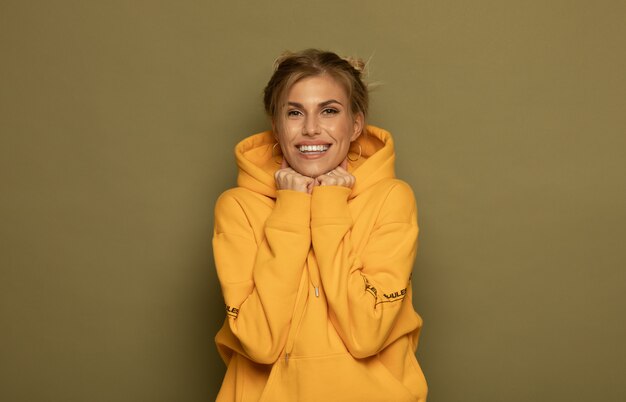 Portrait d'une femme très souriante posant isolé sur un fond de couleur