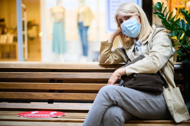 Portrait d'une femme triste pensante portant un masque pour se protéger du virus pandémique Covid 19