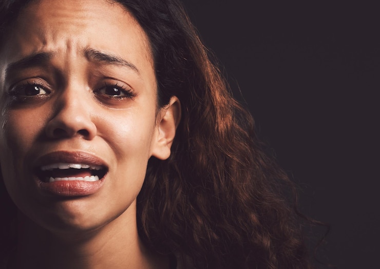 Photo portrait de femme triste et pleurante avec traumatisme pour abus anxiété ou maladie mentale sur un fond de studio sombre personne féminine effrayée ou victime nerveuse avec sentiment d'émotion ou peur en isolement