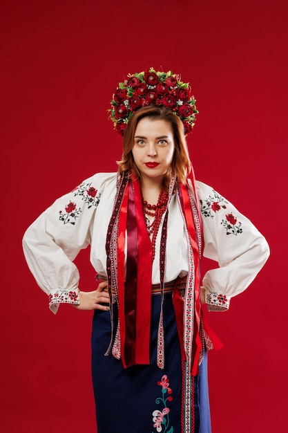 Portrait d'une femme ukrainienne en vêtements ethniques traditionnels et couronne rouge florale sur fond de studio viva magenta Robe brodée nationale ukrainienne appelez vyshyvanka Priez pour l'Ukraine