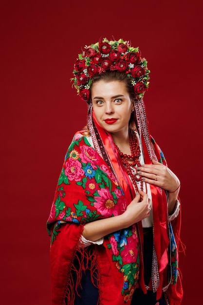 Portrait d'une femme ukrainienne en vêtements ethniques traditionnels et couronne rouge florale sur fond de studio viva magenta Robe brodée nationale ukrainienne appelez vyshyvanka Priez pour l'Ukraine