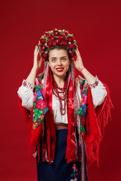 Portrait d'une femme ukrainienne en vêtements ethniques traditionnels et couronne rouge florale sur fond de studio viva magenta Robe brodée nationale ukrainienne appelez vyshyvanka Priez pour l'Ukraine