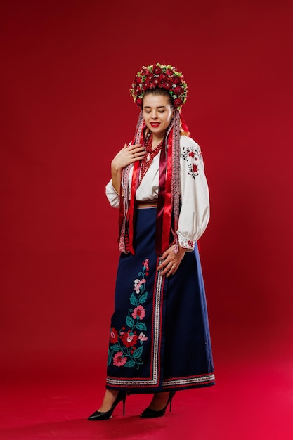 Portrait d'une femme ukrainienne en vêtements ethniques traditionnels et couronne rouge florale sur fond de studio viva magenta Robe brodée nationale ukrainienne appelez vyshyvanka Priez pour l'Ukraine