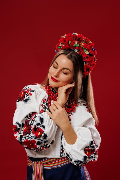 Portrait d'une femme ukrainienne en vêtements ethniques traditionnels et couronne rouge florale sur fond de studio viva magenta Robe brodée nationale ukrainienne appelez vyshyvanka Priez pour l'Ukraine