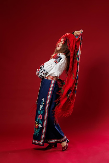 Portrait de femme ukrainienne en vêtements ethniques traditionnels et couronne rouge florale sur fond de studio viva magenta virevolte un mouchoir robe brodée nationale ukrainienne appel vyshyvanka