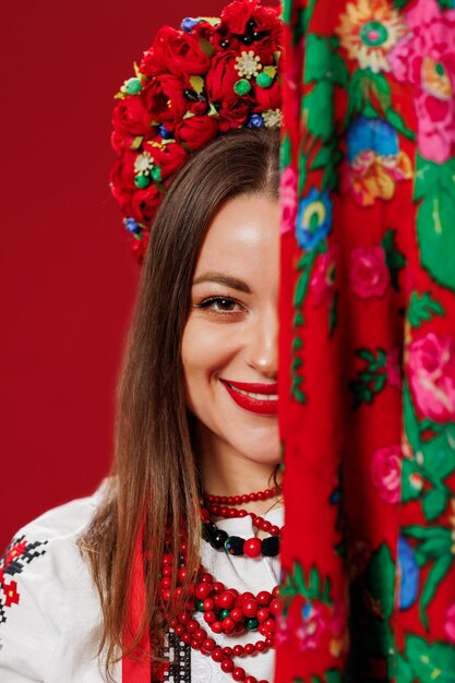 Portrait de femme ukrainienne en vêtements ethniques traditionnels et couronne rouge florale avec mouchoir sur fond de studio viva magenta robe brodée nationale ukrainienne appel vyshyvanka