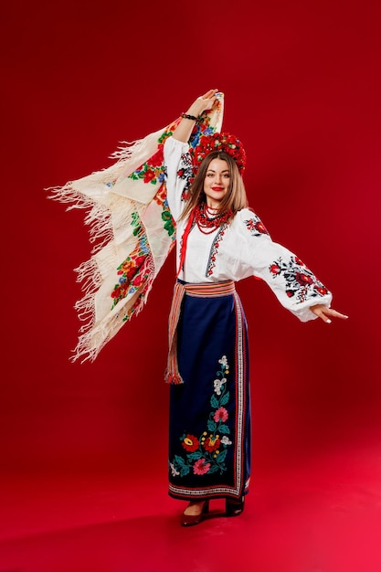 Portrait de femme ukrainienne en vêtements ethniques traditionnels et couronne rouge florale avec mouchoir sur fond de studio viva magenta robe brodée nationale ukrainienne appel vyshyvanka