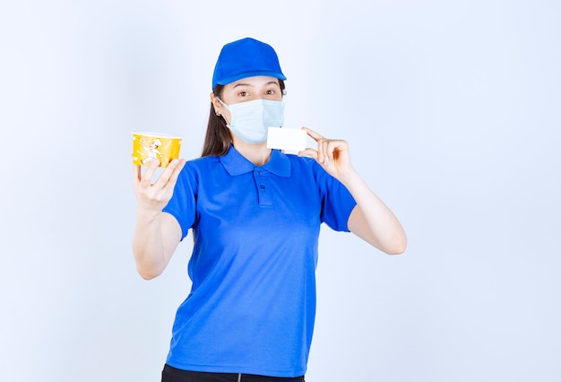 Portrait de femme en uniforme et masque médical holding card